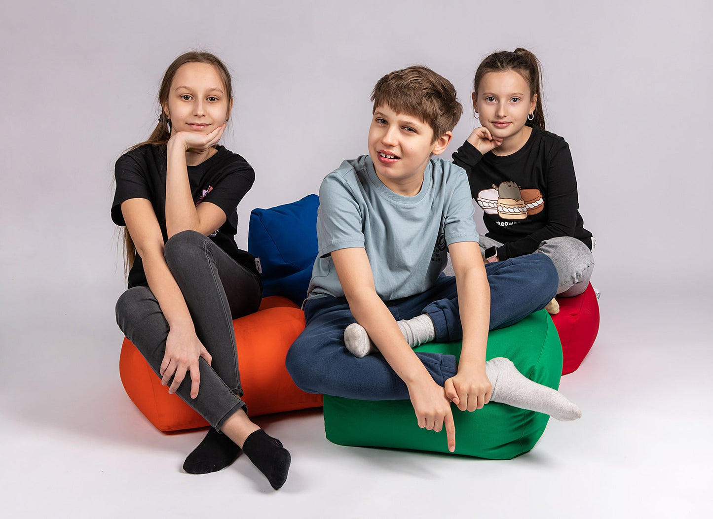 CHILDREN SITTING ON THE COTTON SQUARE POUFS