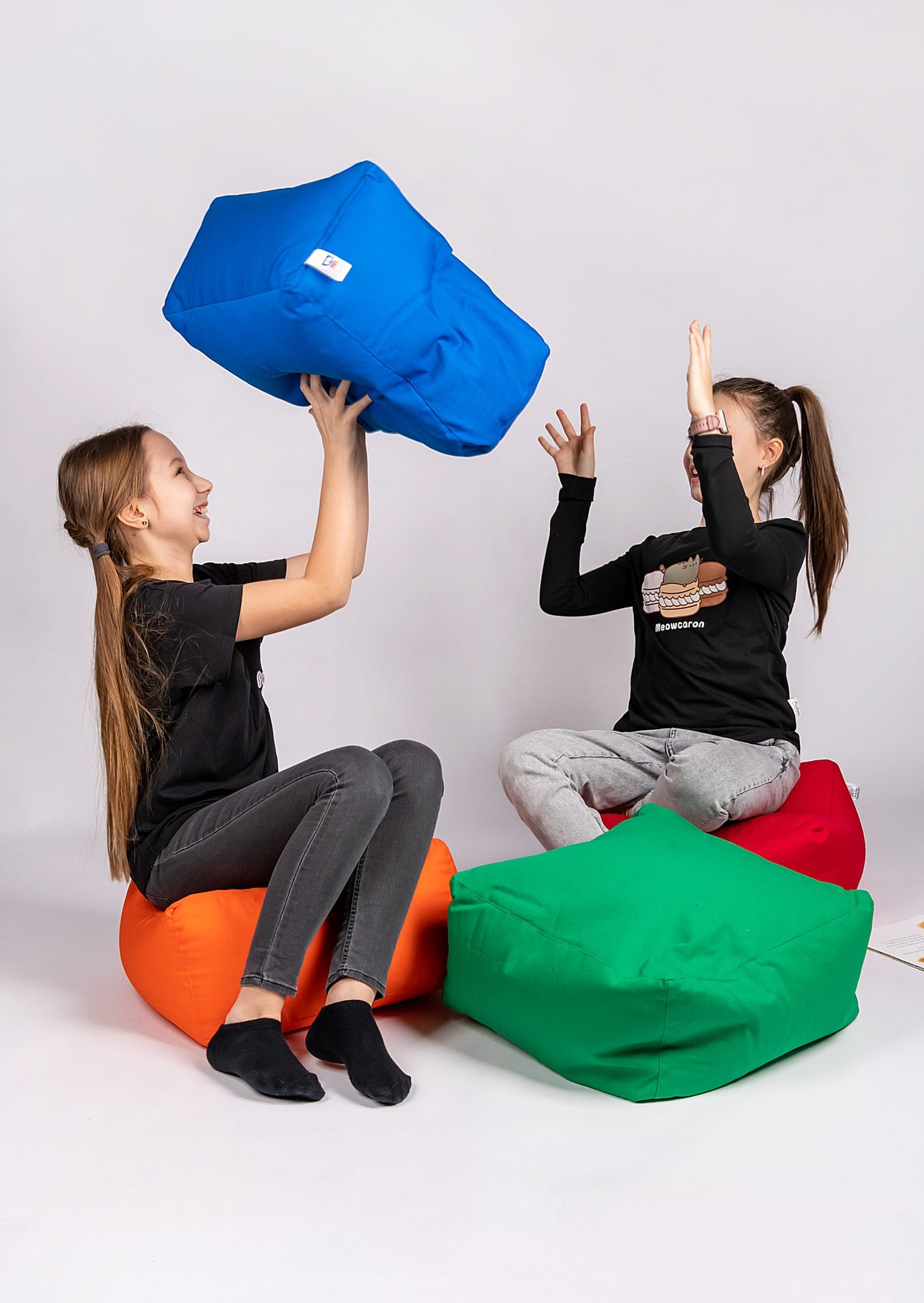 TWO GIRLS PLAYING WITH COTTON SQUARE POUFS