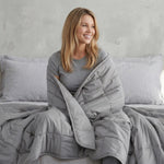 women wrapped in a light grey cotton weighted blanket