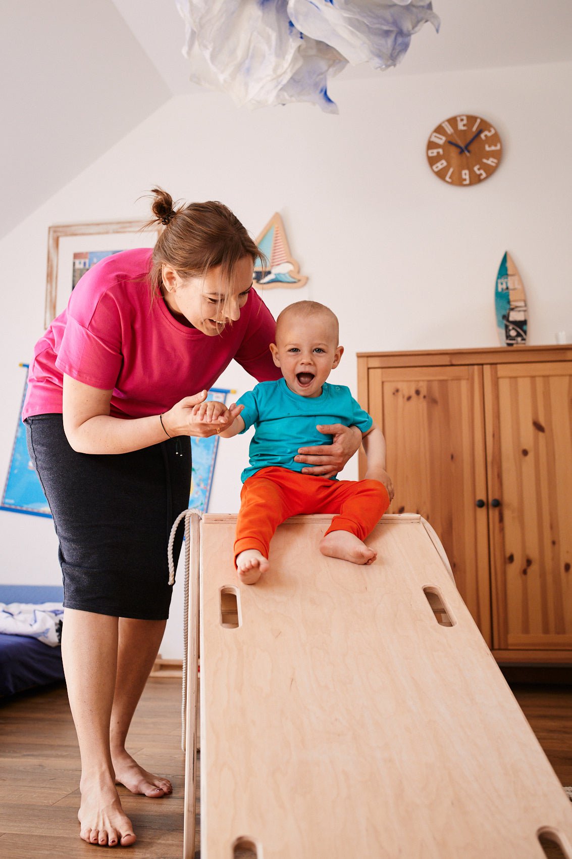 smiling child sliding on the ladder/slider attached to the good wood rocker