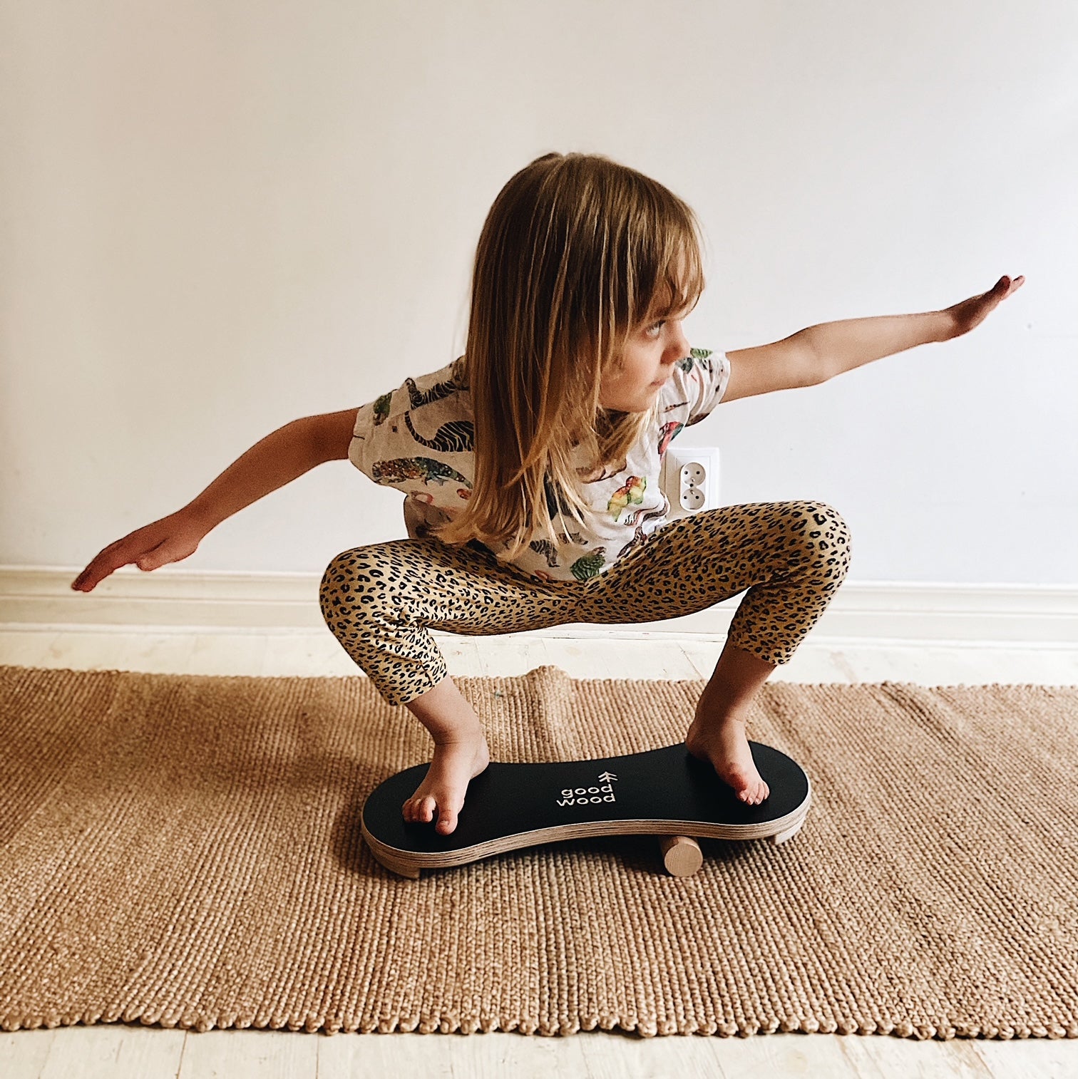 A GIRL HAVING FUN ON THE BLACK BALANCE BOARD / TRICK BOARD FOR KIDS- GOOD WOOD